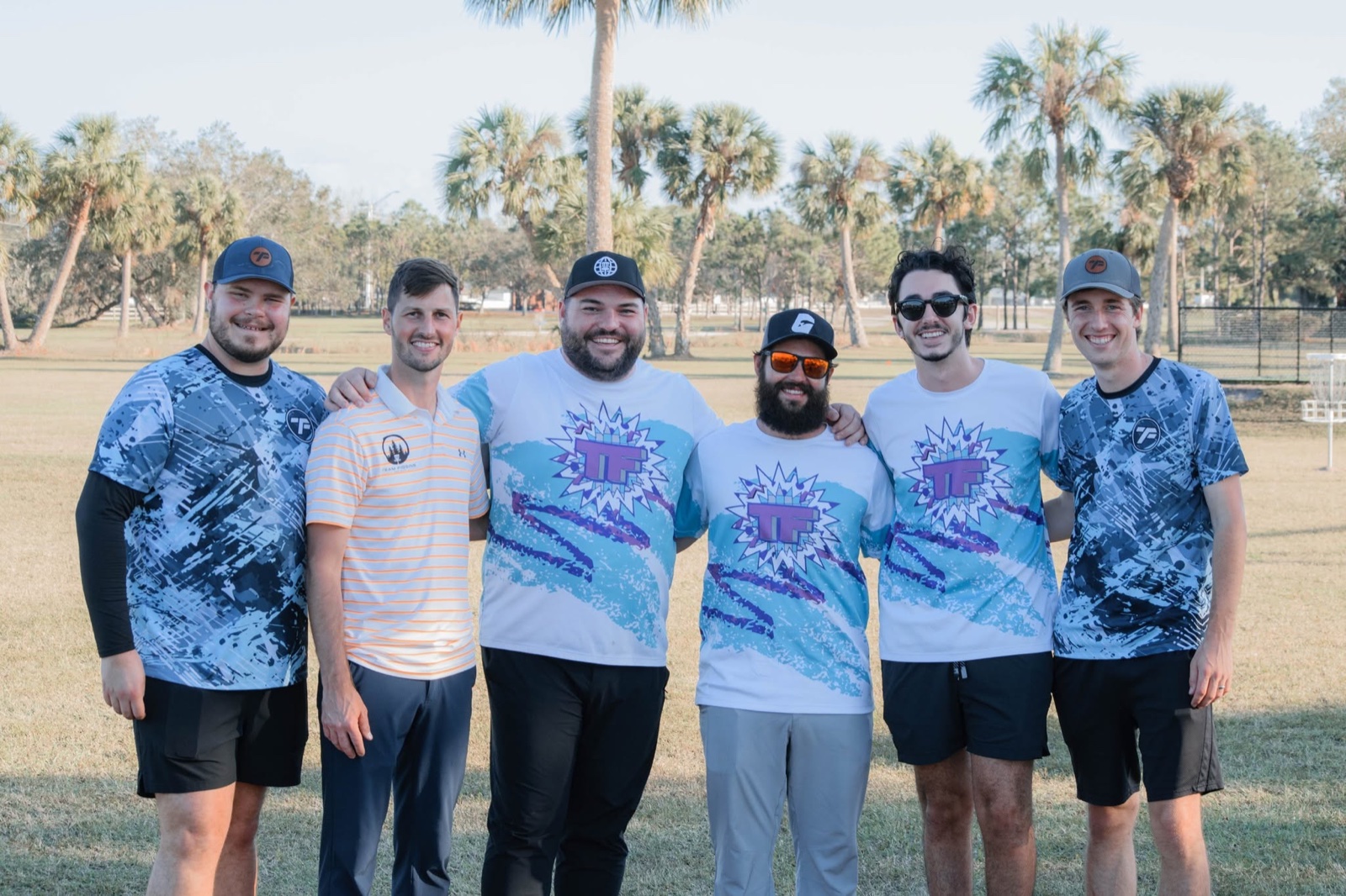 Team Figgins members together on a disc golf course.